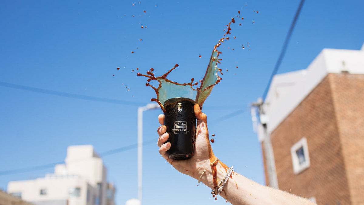 Holding a mannabrew flask with the sky in the background while spilling mannabrew out of the flask
